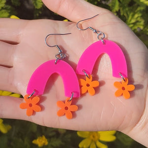 orange flowers hanging from hot pink arch earrings